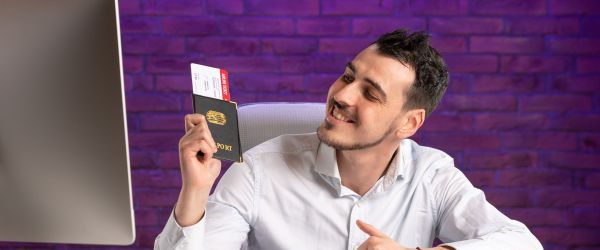front-view-office-worker-sitting-his-working-place-holding-tickets-passport